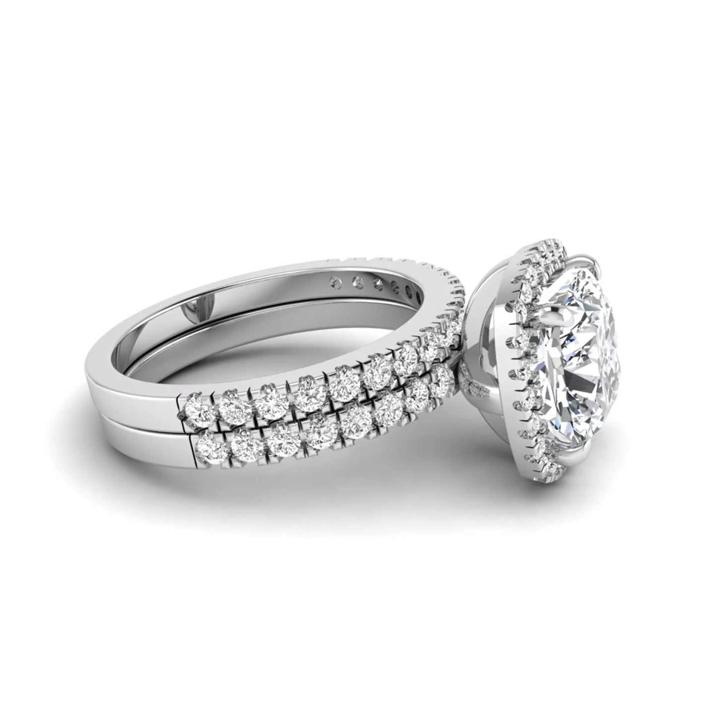 Cushion cut lab grown diamond bridal ring set featuring a halo engagement ring with a matching pavé diamond wedding band in a white gold style design.