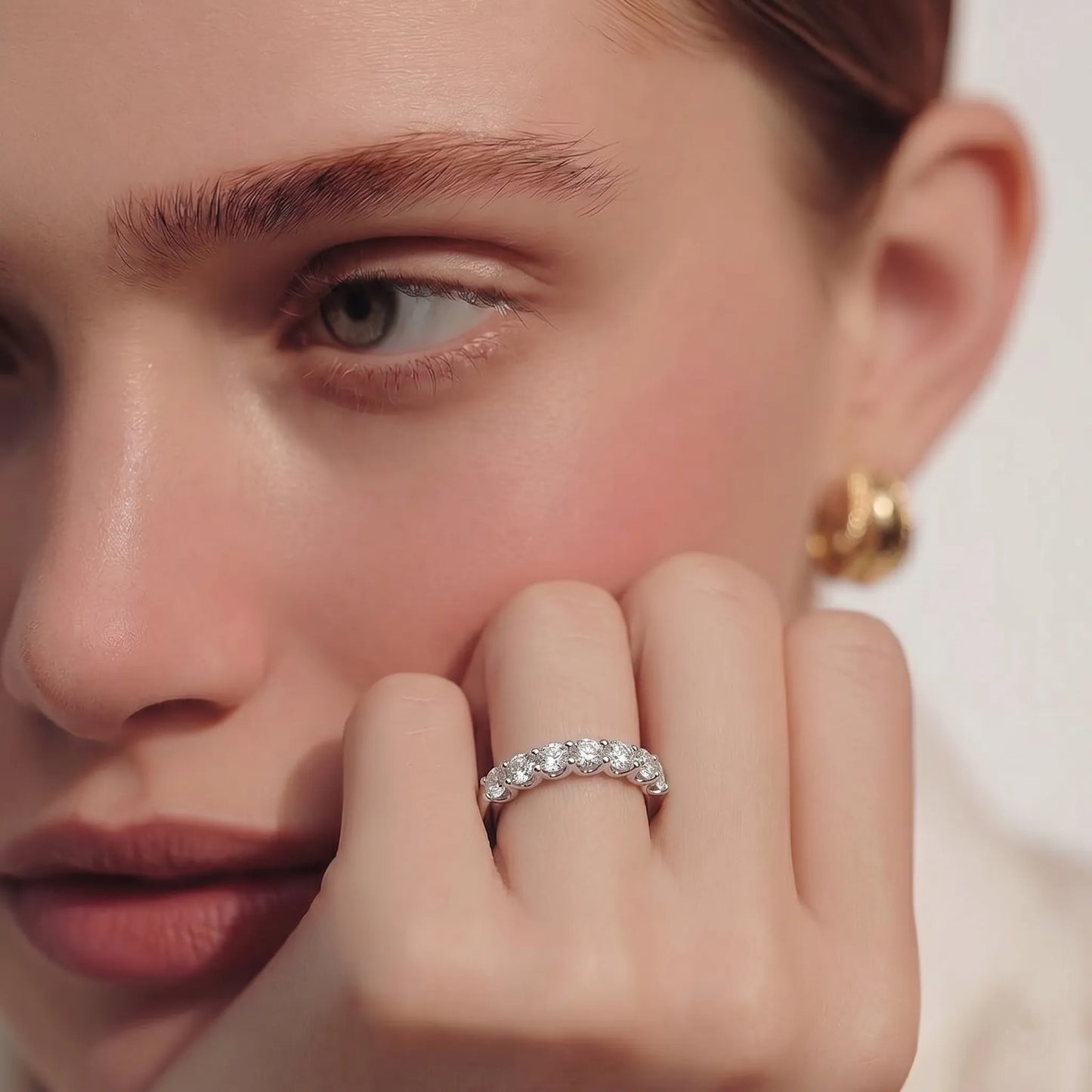 white-gold Close-up of a person wearing a diamond ring on a neutral background