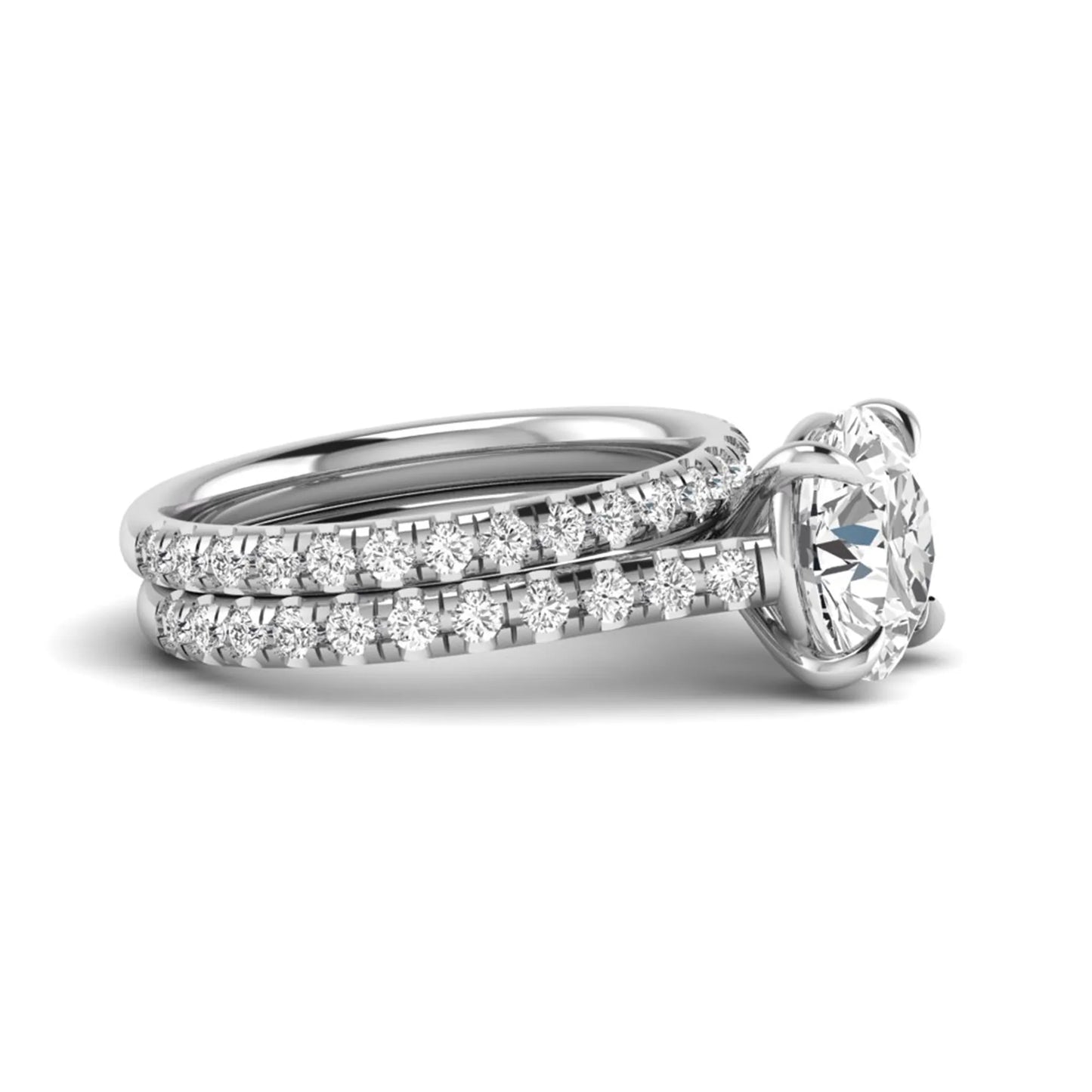 Round cut lab grown diamond bridal ring set featuring a four-prong solitaire center diamond with pavé-set engagement ring and matching pavé wedding band in a white gold finish.