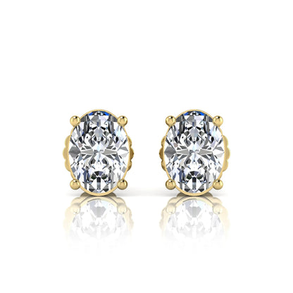 yellow Gold earrings with large clear gemstones on a white background