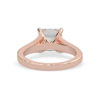 Rose gold ring with a clear gemstone on a white background