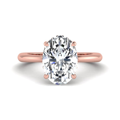 IGI certified oval cut lab grown diamond engagement ring featuring a four-prong setting with a hidden halo of round accent diamonds in rose gold tone.