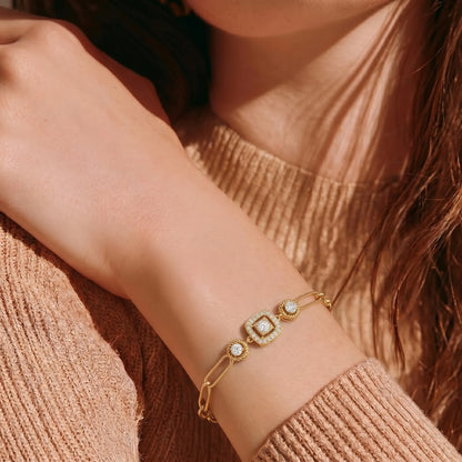 yellow-Gold rose-gold white-gold bracelet with diamond accents on a wrist, wearing a beige sweater.