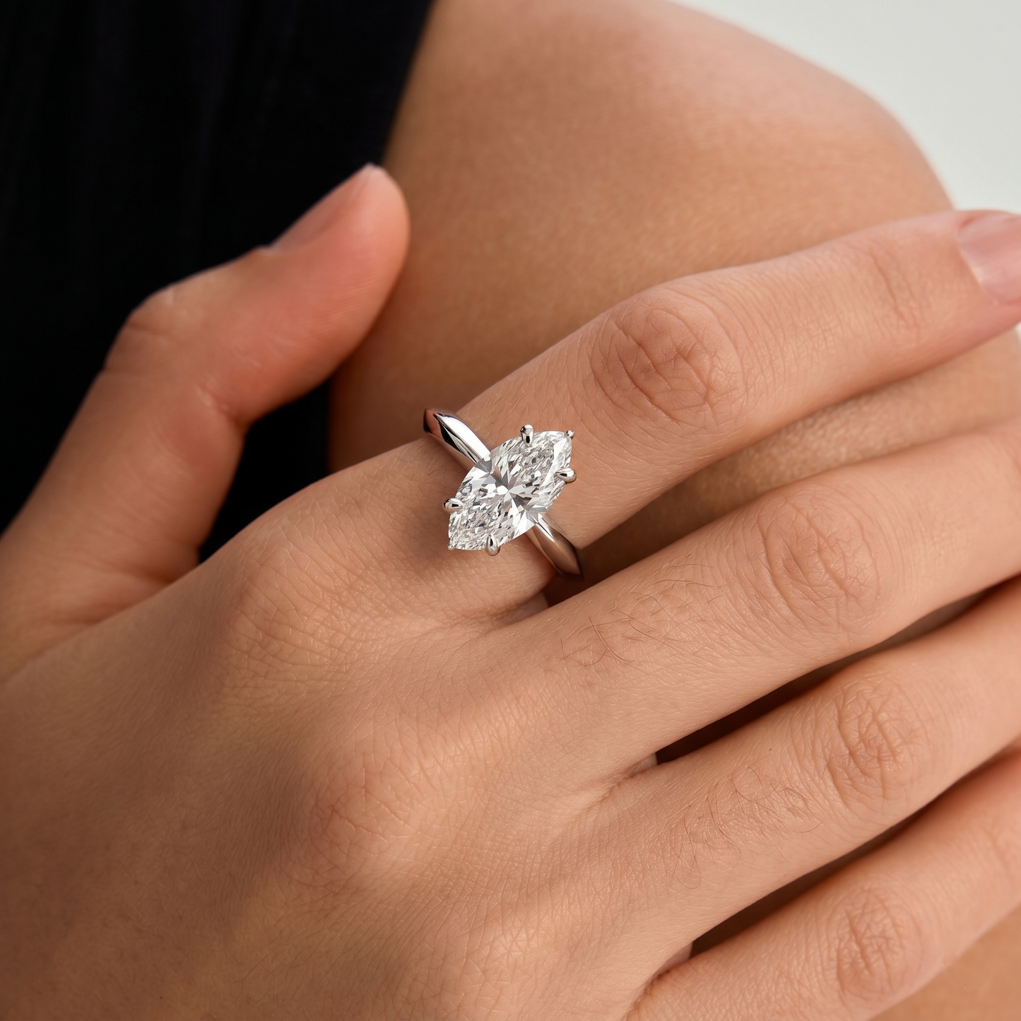 yellow-gold  Diamond ring on a person's finger with a neutral background