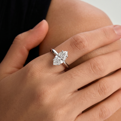yellow-gold  Diamond ring on a person's finger with a neutral background