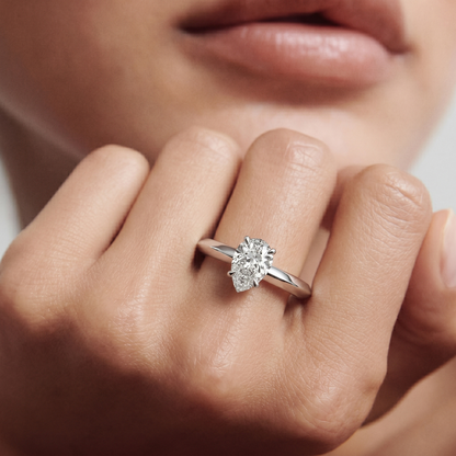 yellow gold Close-up of a hand wearing a diamond ring with a soft focus background