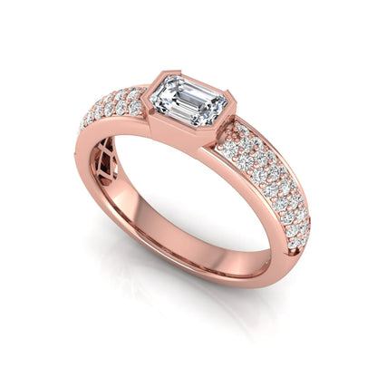 Bezel set emerald cut lab grown diamond engagement ring featuring a 0.52 carat emerald center diamond with pavé round diamond band in rose gold.