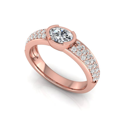 Bezel set oval lab grown diamond engagement ring featuring a 0.52 carat oval center diamond with pavé round diamond band in rose gold.