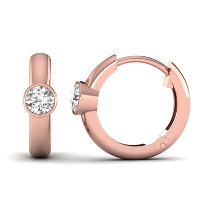 Bezel set round cut lab grown diamond huggie hoop earrings featuring a hinged snap closure and polished rose gold design.