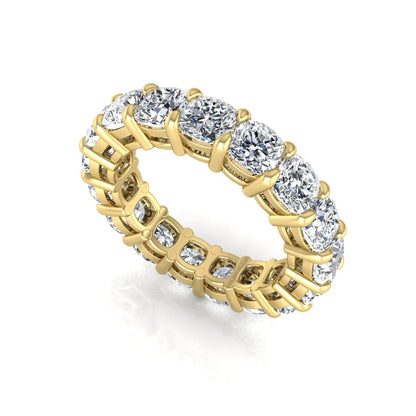 Cushion cut lab grown diamond eternity band ring featuring shared prong set diamonds with a yellow gold tone design.