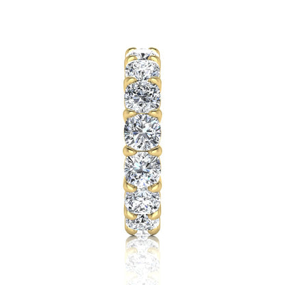 Cushion cut lab grown diamond eternity band ring featuring shared prong set diamonds with a yellow gold tone design.