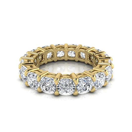 Cushion cut lab grown diamond eternity band ring featuring shared prong set diamonds with a yellow gold tone design.