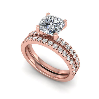 Cushion cut lab grown diamond bridal ring set featuring a four-prong solitaire engagement ring with a matching pavé diamond wedding band in a rose gold tone design.