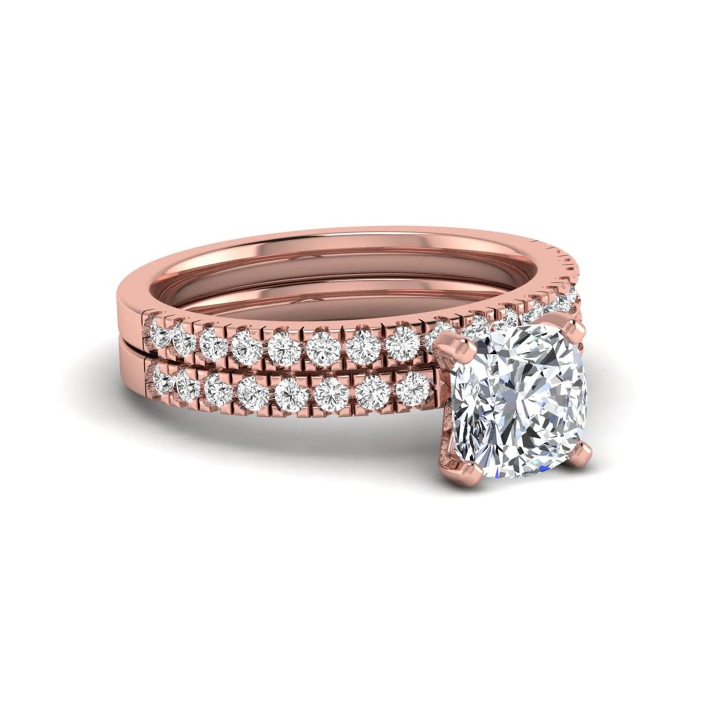 Cushion cut lab grown diamond bridal ring set featuring a four-prong solitaire engagement ring with a matching pavé diamond wedding band in a rose gold tone design.
