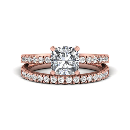 Cushion cut lab grown diamond bridal ring set featuring a four-prong solitaire engagement ring with a matching pavé diamond wedding band in a rose gold tone design.