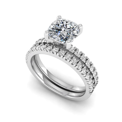Cushion cut lab grown diamond bridal ring set featuring a four-prong solitaire engagement ring with a matching pavé diamond wedding band in a white gold tone design.