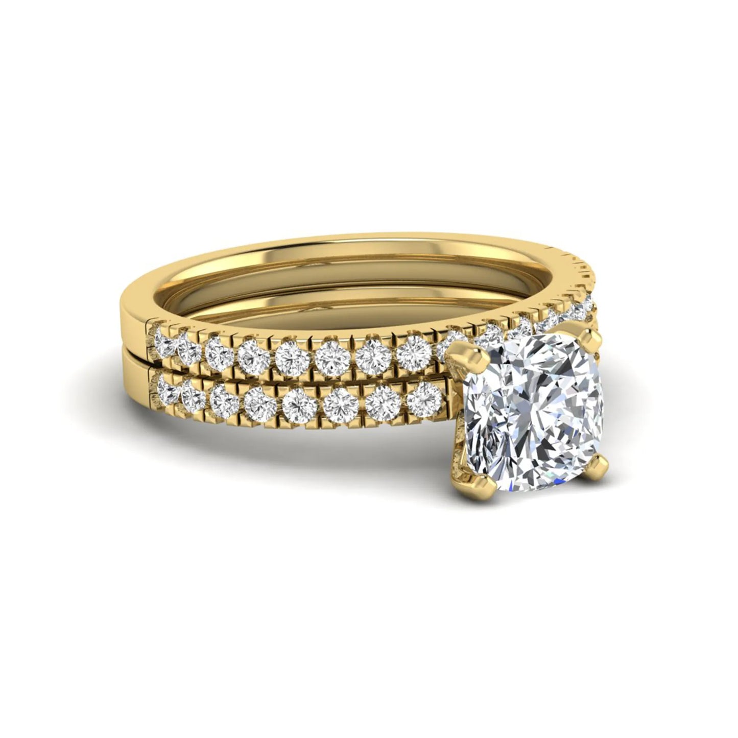 Cushion cut lab grown diamond bridal ring set featuring a four-prong solitaire engagement ring with a matching pavé diamond wedding band in a yellow gold tone design.