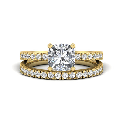 Cushion cut lab grown diamond bridal ring set featuring a four-prong solitaire engagement ring with a matching pavé diamond wedding band in a yellow gold tone design.