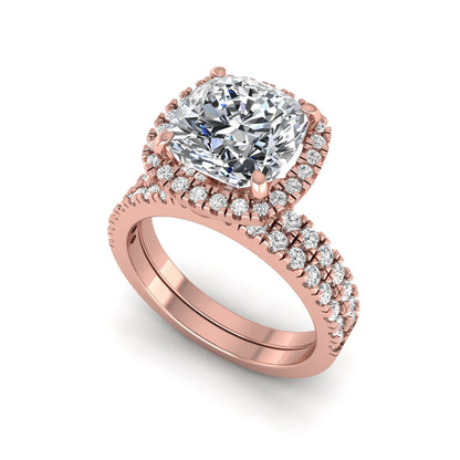 Cushion cut lab grown diamond bridal ring set featuring a halo engagement ring with a matching pavé diamond wedding band in a rose gold style design.