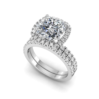 Cushion cut lab grown diamond bridal ring set featuring a halo engagement ring with a matching pavé diamond wedding band in a white gold style design.