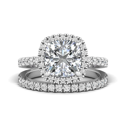 Cushion cut lab grown diamond bridal ring set featuring a halo engagement ring with a matching pavé diamond wedding band in a white gold style design.