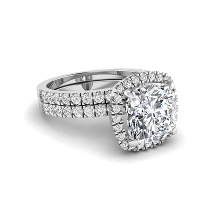 Cushion cut lab grown diamond bridal ring set featuring a halo engagement ring with a matching pavé diamond wedding band in a white gold style design.