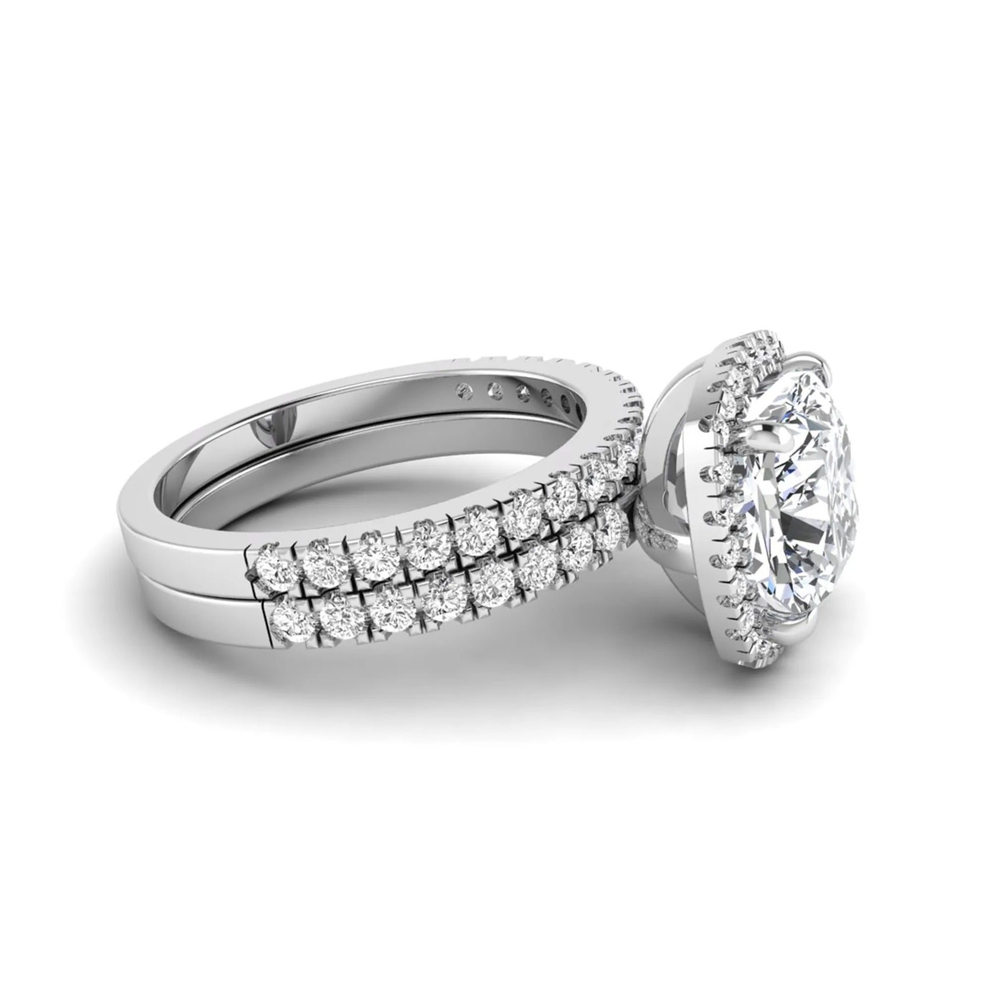 Cushion cut lab grown diamond bridal ring set featuring a halo engagement ring with a matching pavé diamond wedding band in a white gold style design.