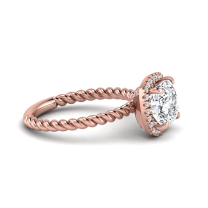 Cushion cut lab grown diamond halo engagement ring featuring a twisted rope band, four-prong setting, and round accent diamonds in a rose gold tone design.