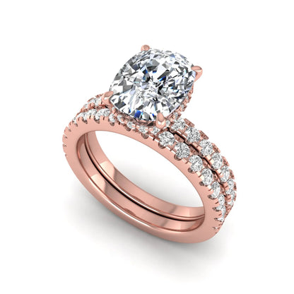 Cushion cut lab grown diamond hidden halo bridal ring set with pavé round diamonds and matching wedding band in a rose gold tone finish.