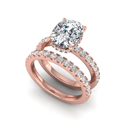 Cushion cut lab grown diamond hidden halo bridal ring set with pavé round diamonds and matching wedding band in a rose gold tone finish.