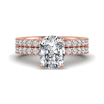Cushion cut lab grown diamond hidden halo bridal ring set with pavé round diamonds and matching wedding band in a rose gold tone finish.
