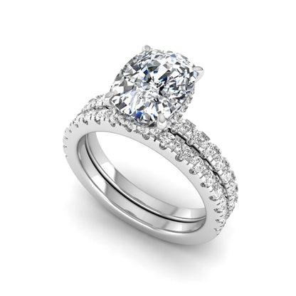 Cushion cut lab grown diamond hidden halo bridal ring set with pavé round diamonds and matching wedding band in a white gold tone finish.