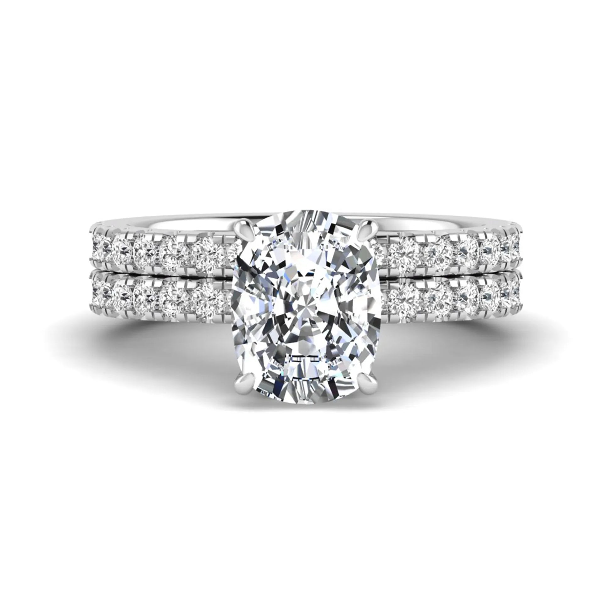 Cushion cut lab grown diamond hidden halo bridal ring set with pavé round diamonds and matching wedding band in a white gold tone finish.