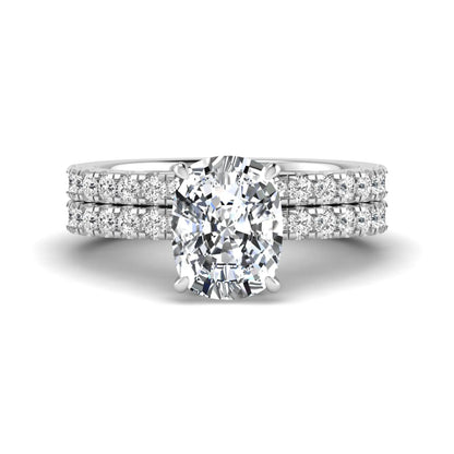 Cushion cut lab grown diamond hidden halo bridal ring set with pavé round diamonds and matching wedding band in a white gold tone finish.