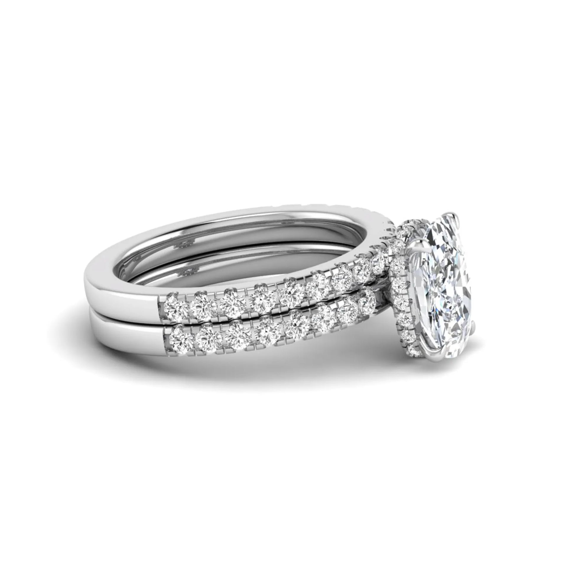 Cushion cut lab grown diamond hidden halo bridal ring set with pavé round diamonds and matching wedding band in a white gold tone finish.