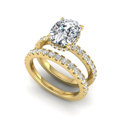 Cushion cut lab grown diamond hidden halo bridal ring set with pavé round diamonds and matching wedding band in a yellow gold tone finish.