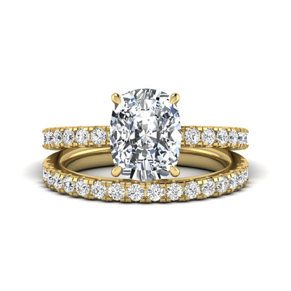 Cushion cut lab grown diamond hidden halo bridal ring set with pavé round diamonds and matching wedding band in a yellow gold tone finish.