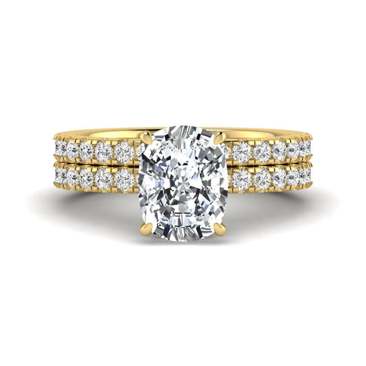Cushion cut lab grown diamond hidden halo bridal ring set with pavé round diamonds and matching wedding band in a yellow gold tone finish.