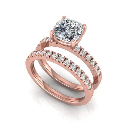 Cushion cut lab grown diamond bridal ring set featuring a four-prong solitaire engagement ring with pavé round diamond accents and matching wedding band in rose gold finish.