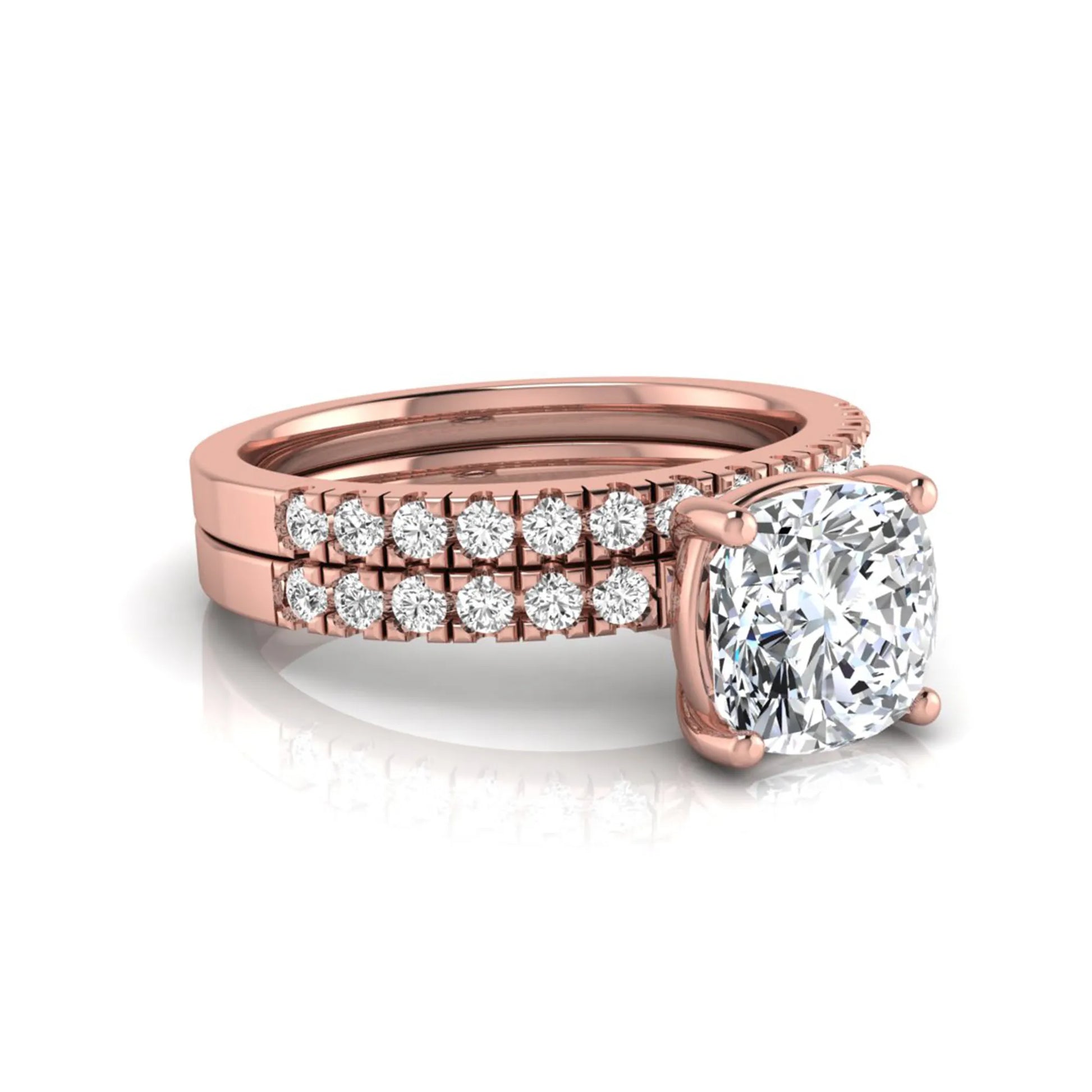 Cushion cut lab grown diamond bridal ring set featuring a four-prong solitaire engagement ring with pavé round diamond accents and matching wedding band in rose gold finish.