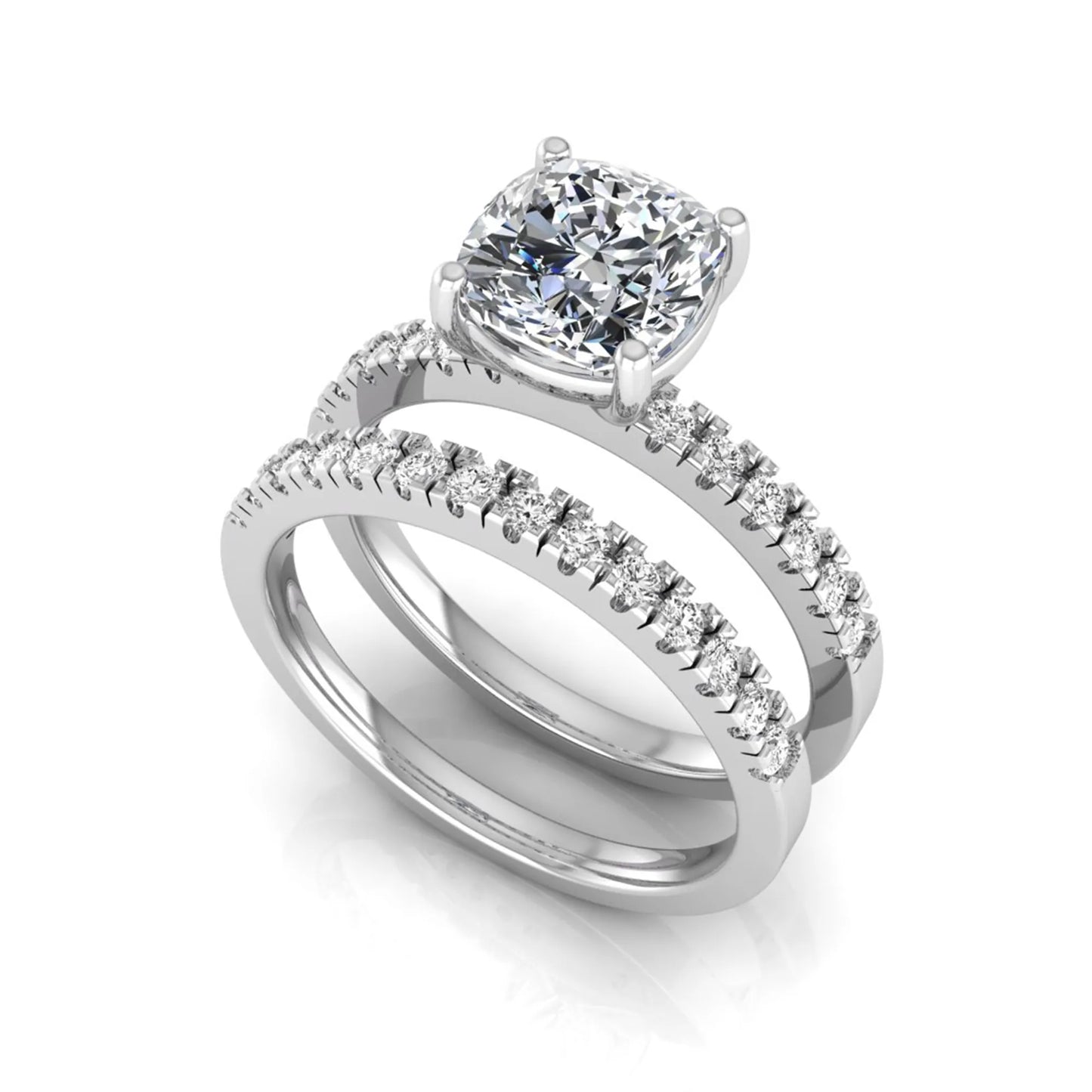 Cushion cut lab grown diamond bridal ring set featuring a four-prong solitaire engagement ring with pavé round diamond accents and matching wedding band in white gold finish.