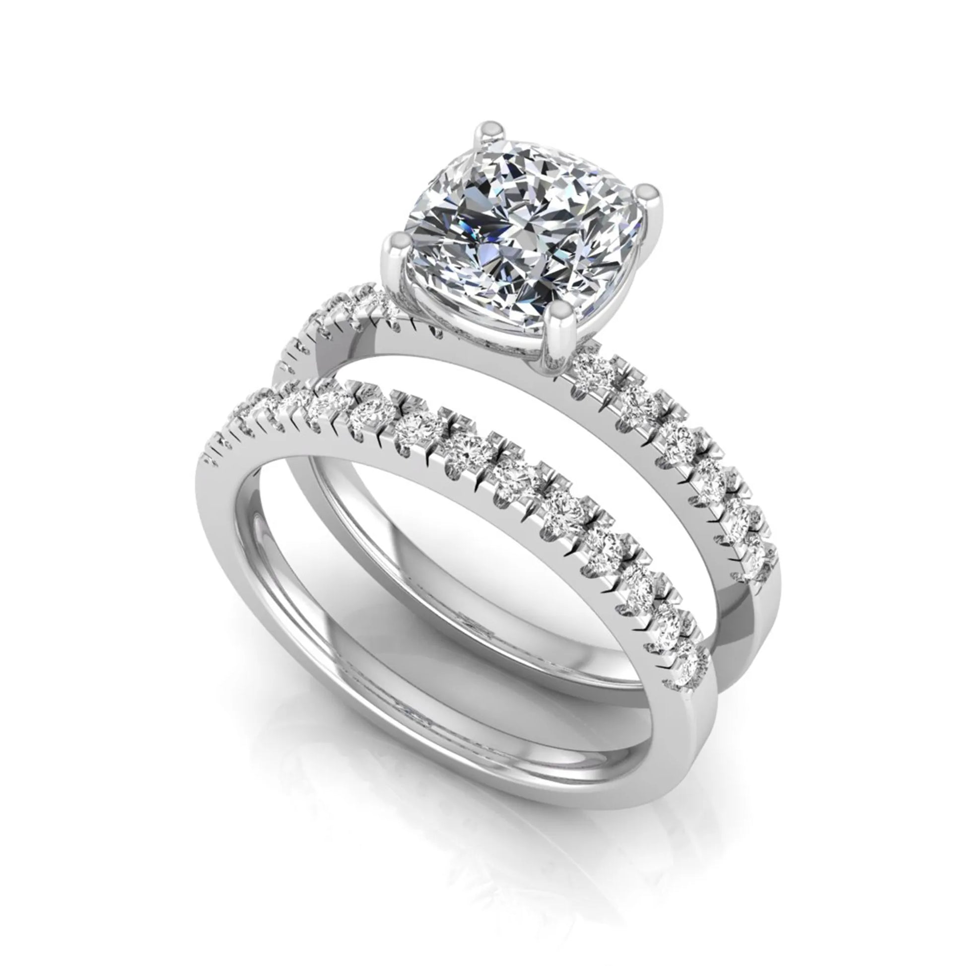 Cushion cut lab grown diamond bridal ring set featuring a four-prong solitaire engagement ring with pavé round diamond accents and matching wedding band in white gold finish.