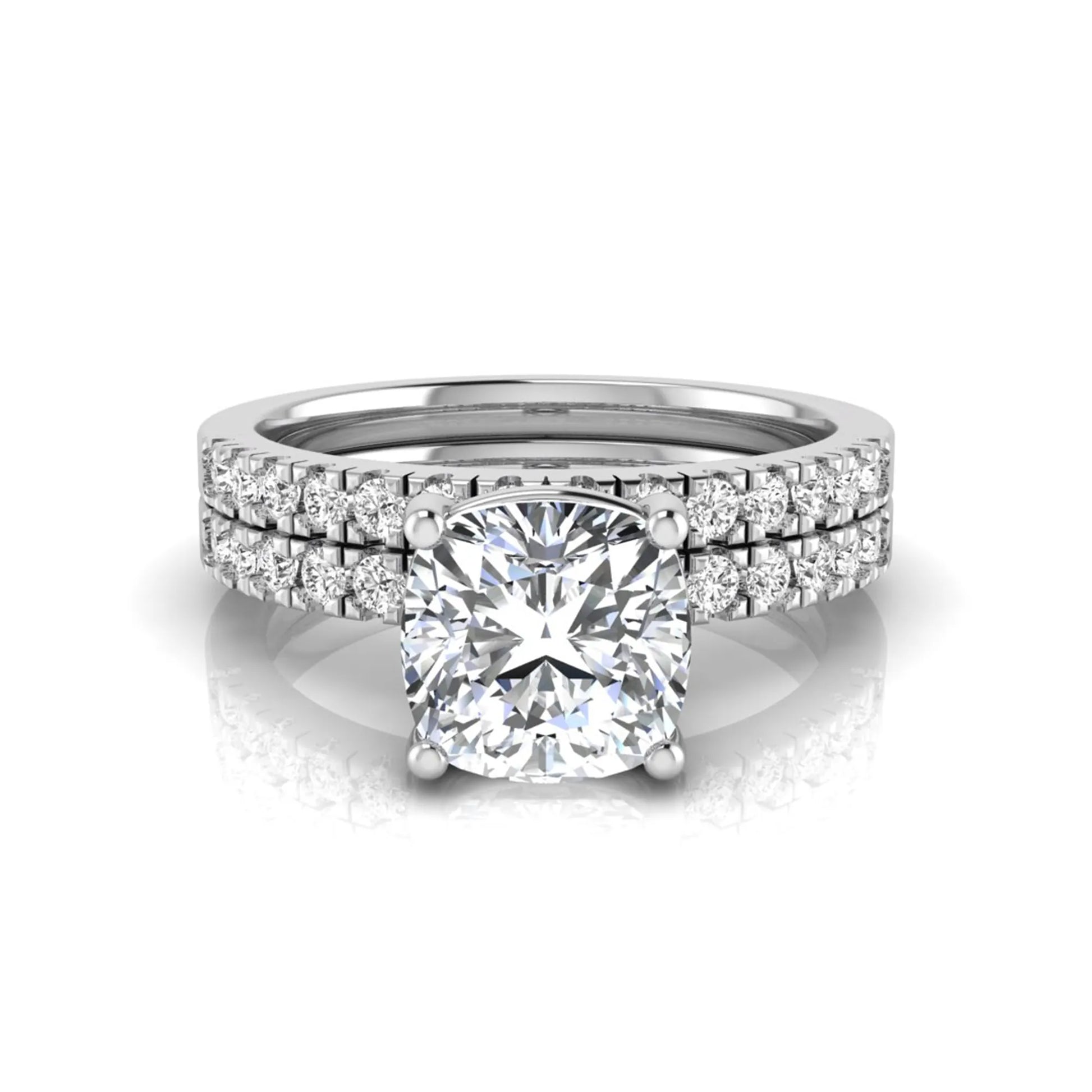 Cushion cut lab grown diamond bridal ring set featuring a four-prong solitaire engagement ring with pavé round diamond accents and matching wedding band in white gold finish.