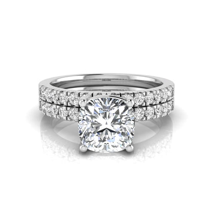 Cushion cut lab grown diamond bridal ring set featuring a four-prong solitaire engagement ring with pavé round diamond accents and matching wedding band in white gold finish.