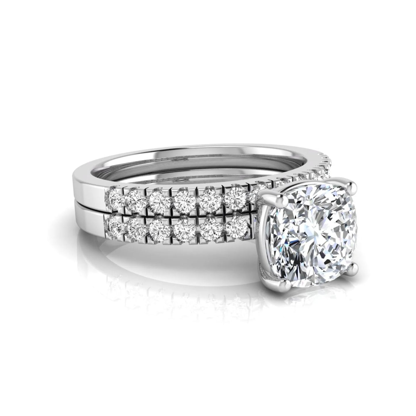 Cushion cut lab grown diamond bridal ring set featuring a four-prong solitaire engagement ring with pavé round diamond accents and matching wedding band in white gold finish.