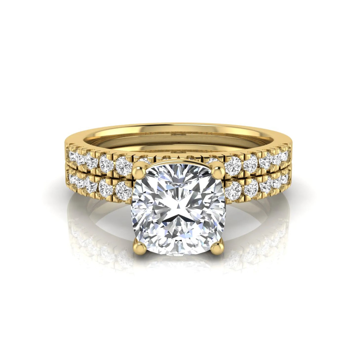 Cushion cut lab grown diamond bridal ring set featuring a four-prong solitaire engagement ring with pavé round diamond accents and matching wedding band in yellow gold finish.