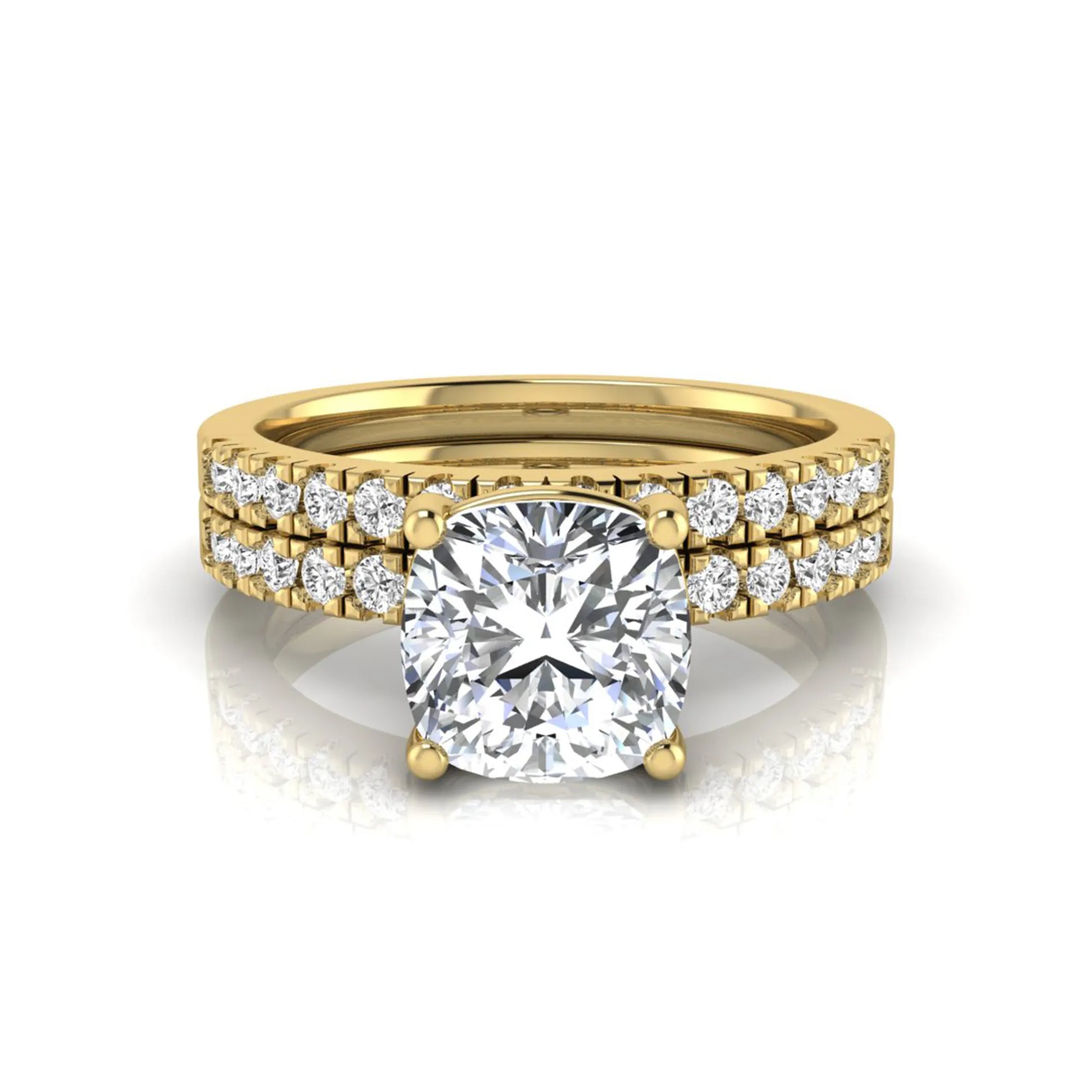 Cushion cut lab grown diamond bridal ring set featuring a four-prong solitaire engagement ring with pavé round diamond accents and matching wedding band in yellow gold finish.