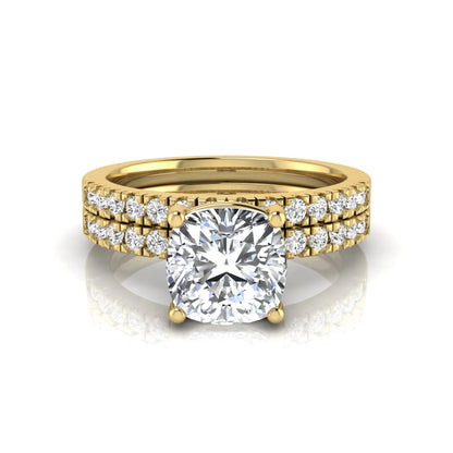 Cushion cut lab grown diamond bridal ring set featuring a four-prong solitaire engagement ring with pavé round diamond accents and matching wedding band in yellow gold finish.