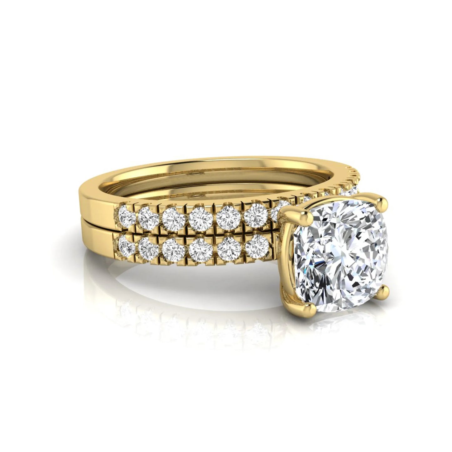 Cushion cut lab grown diamond bridal ring set featuring a four-prong solitaire engagement ring with pavé round diamond accents and matching wedding band in yellow gold finish.