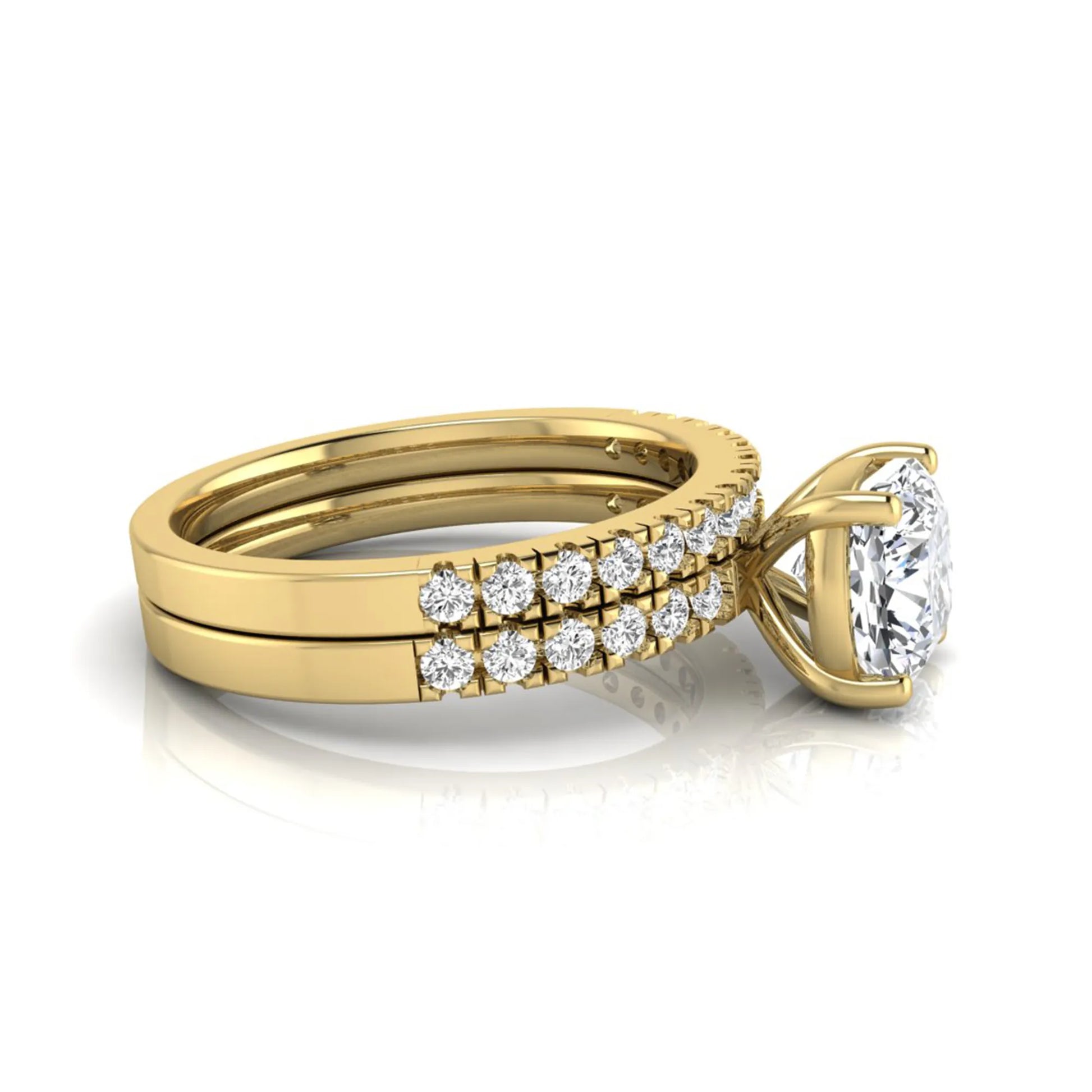 Cushion cut lab grown diamond bridal ring set featuring a four-prong solitaire engagement ring with pavé round diamond accents and matching wedding band in yellow gold finish.